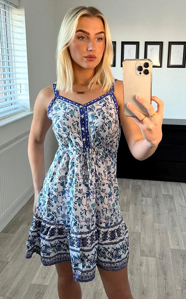 Zomerminijurk met ruchedetail in wit-blauwe sterrenbloemenprint